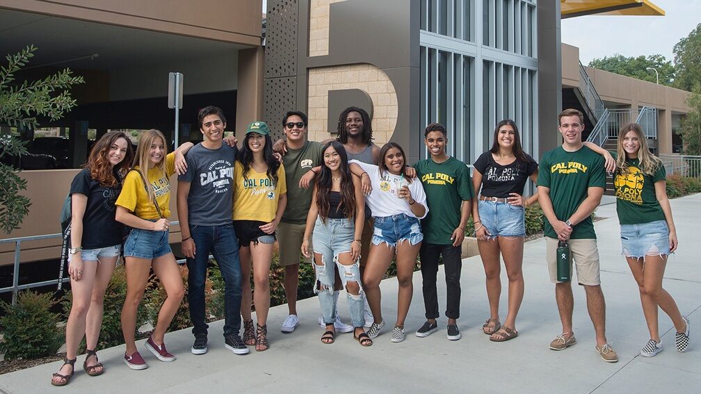 A group of young, casually dressed students pose in a semi-circle facing the camera
