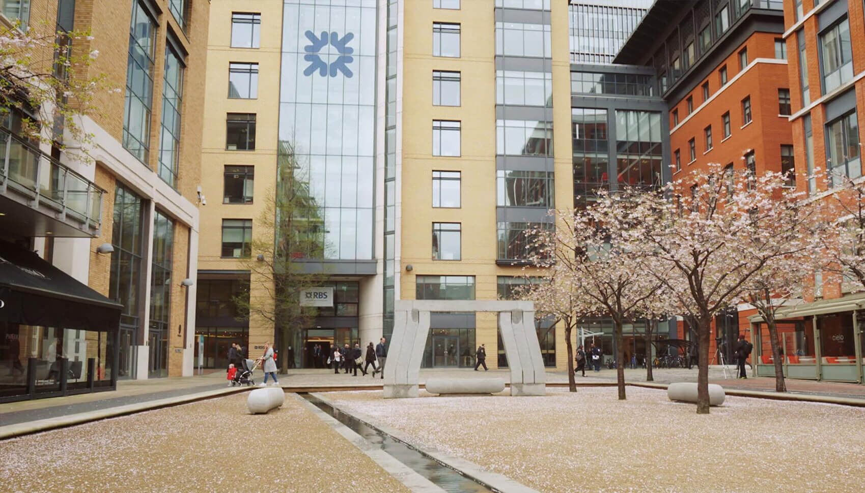 A view of a Royal Bank of Scotland (RBS) building with a large fountain in the foreground