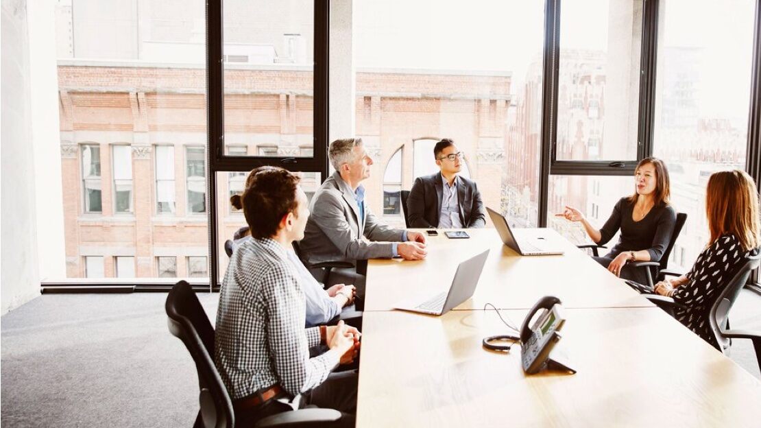  A group of people surrounding a board room table